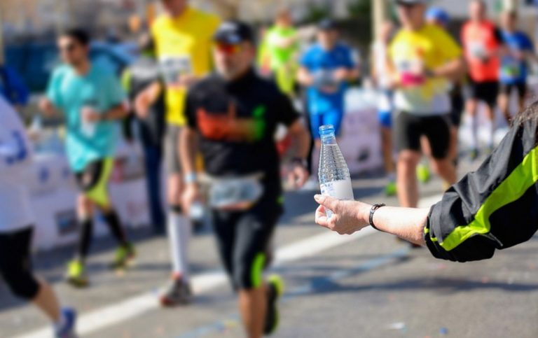 Person handing out bottled water for runners