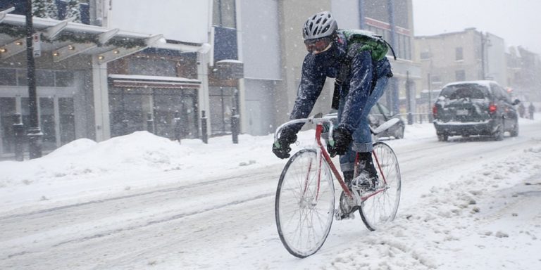 Person cycling on snowy street